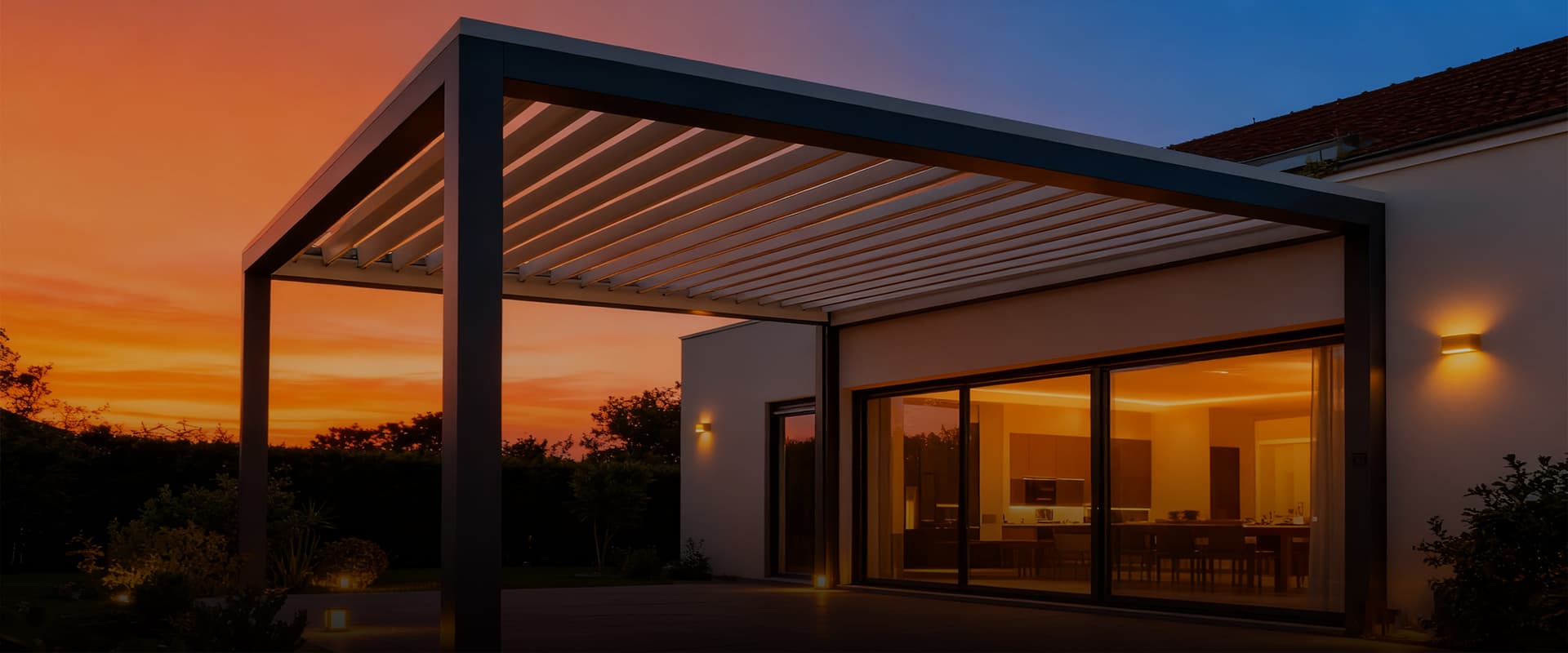 Aluminum louvered pergola installed beside a modern home at sunset